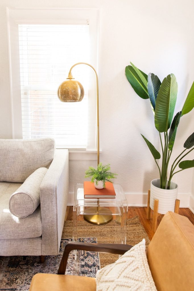 Our Airbnb room with plants for decor and a statement floor lamp.