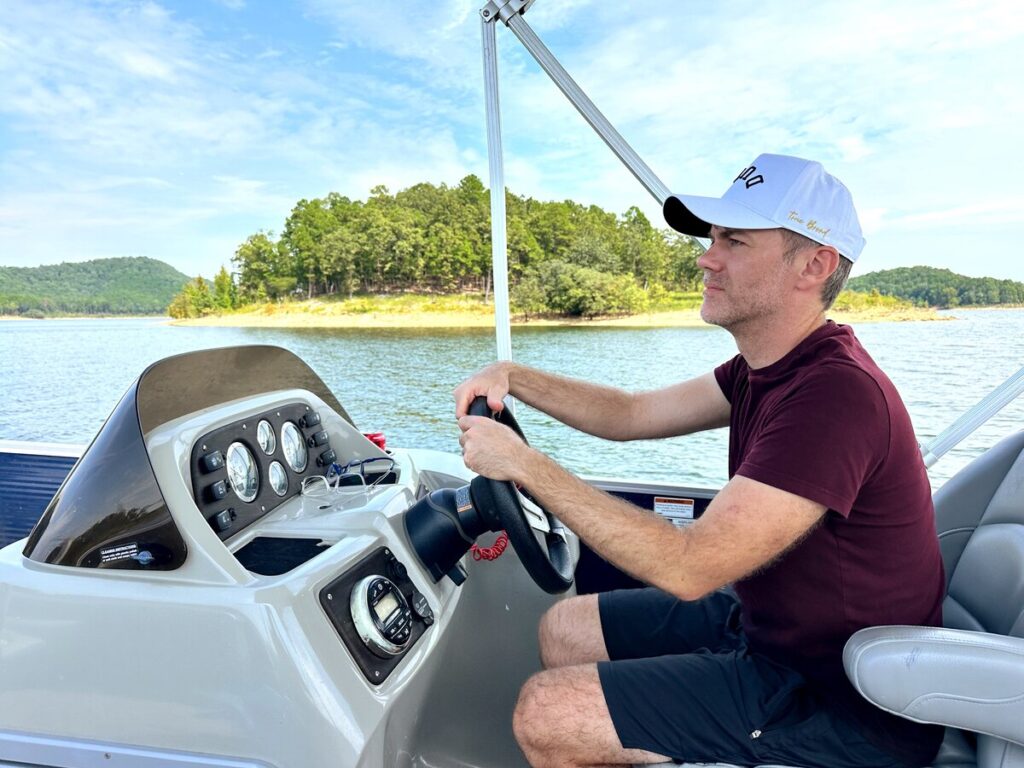 My husband driving a boat on Broken Bow Lake in Oklahoma.