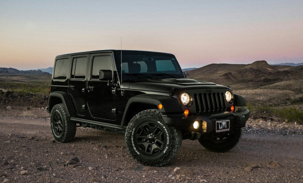 Jeep Wrangler driving through the plains at sunset.