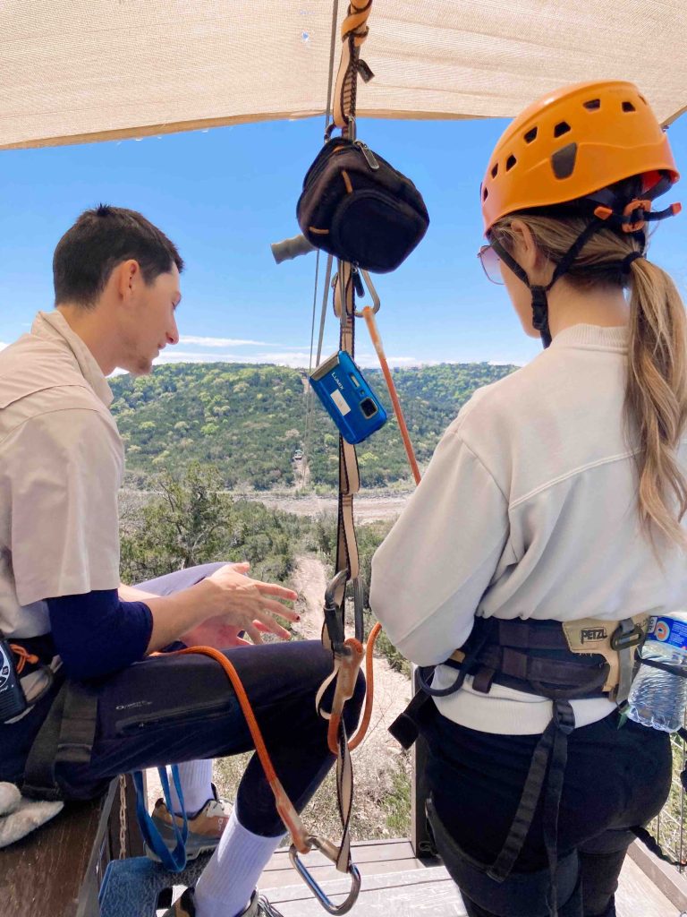 Our guide setting up my harness as I'm about to zip line over Lake Travis.
