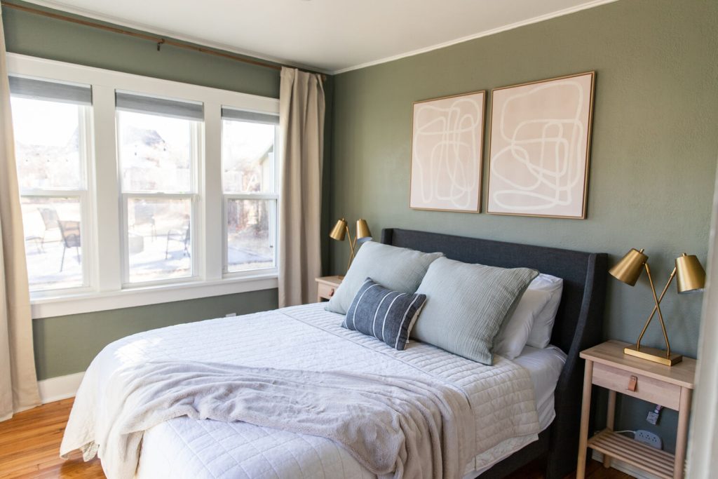 Beautifully styled guest bedroom with cozy bedding, great lighting, and stunning wall art.