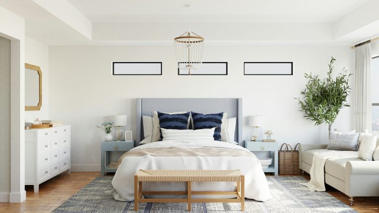 Airbnb bedroom with cozy bed, sofa, mirror and dresser. The light and bright feel, textured elements, and faux plant make the space warm and inviting.