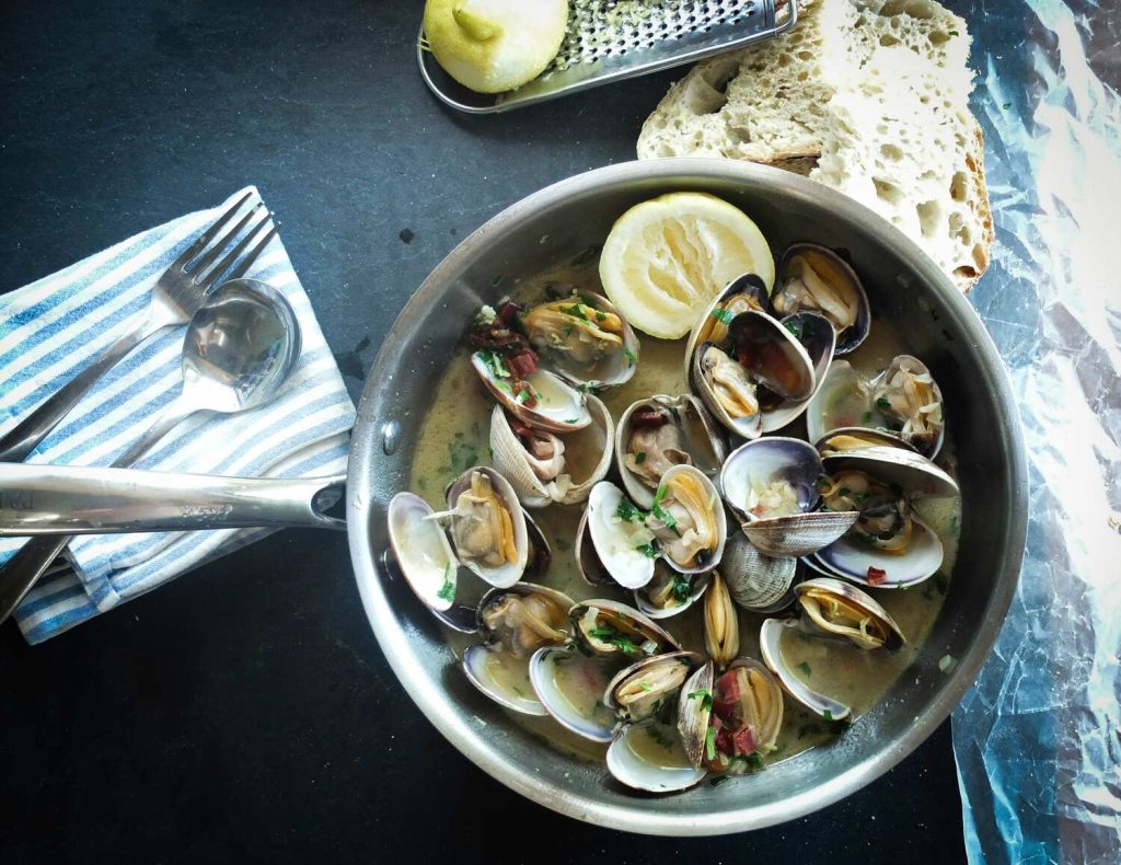 A beautiful serving of clams in a pan at a seafood restaurant.