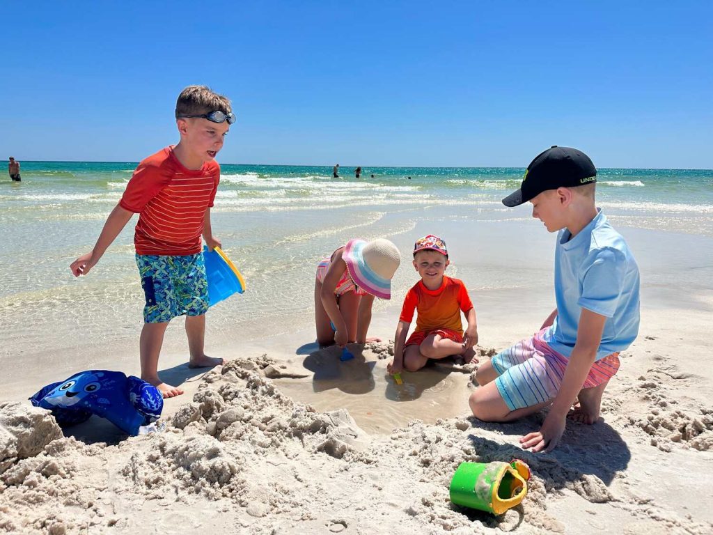 Our kids and toddlers playing on the beach with beach toys.