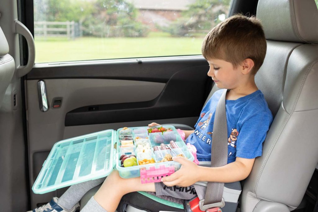Our son on a road trip with road trip snacks.