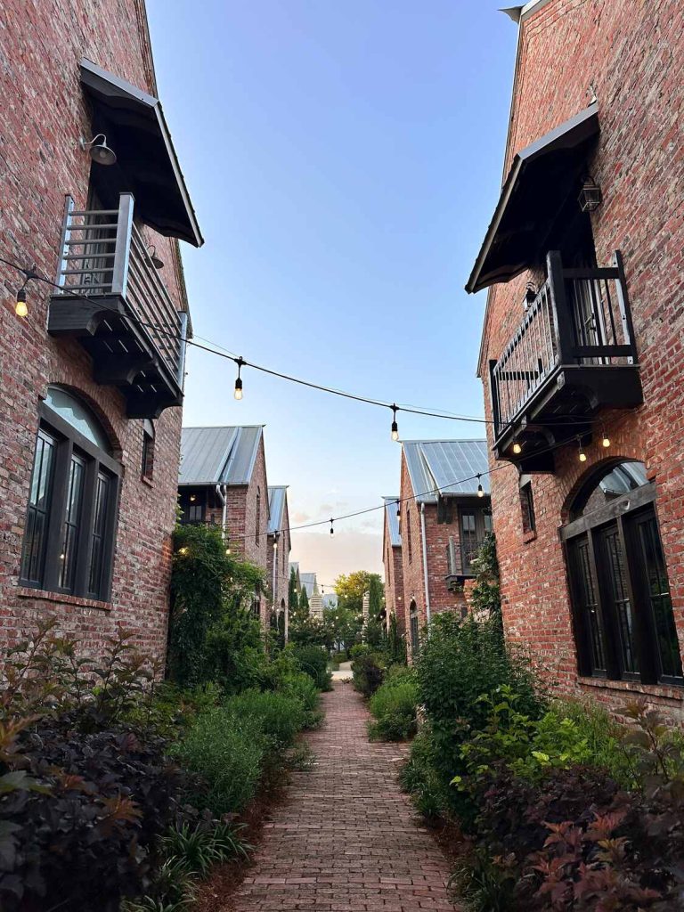 A beautiful path between rental homes surrounded by string lights in Carlton Landing, OK.