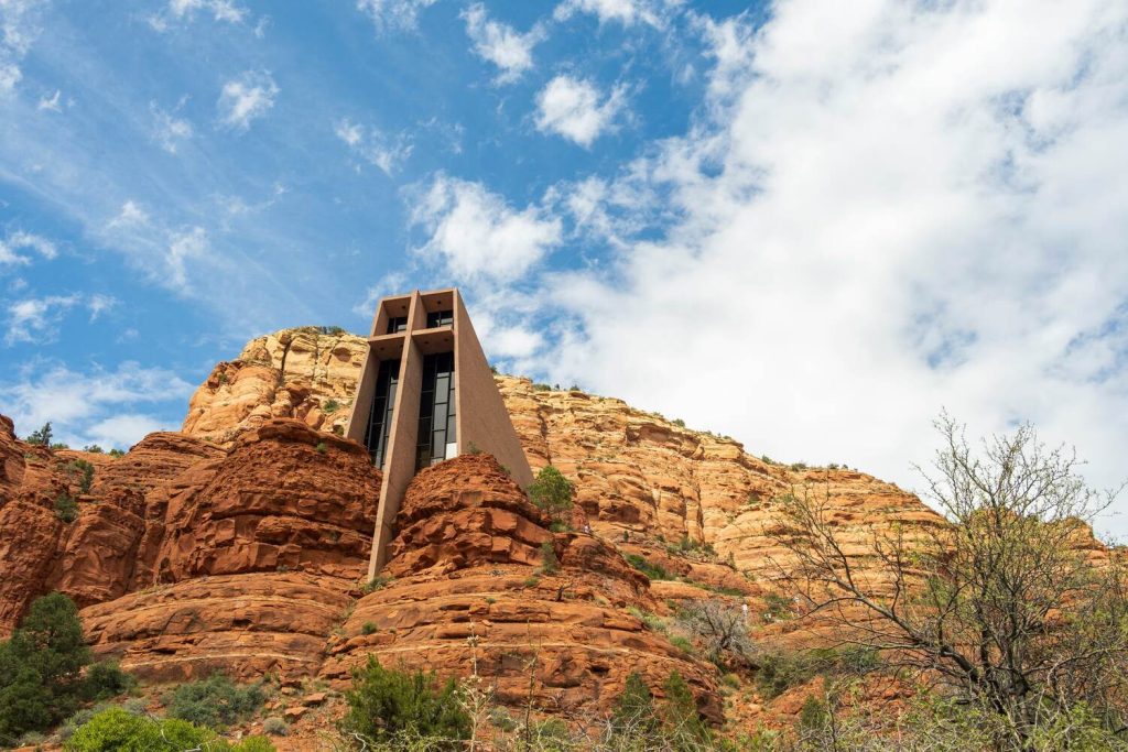 View of Chapel of the Holy Cross against the red rocks and blue sky.