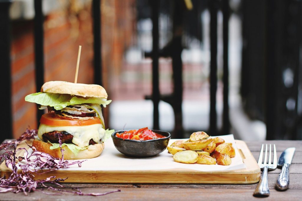 Stacked burger with hand-cut french fries.