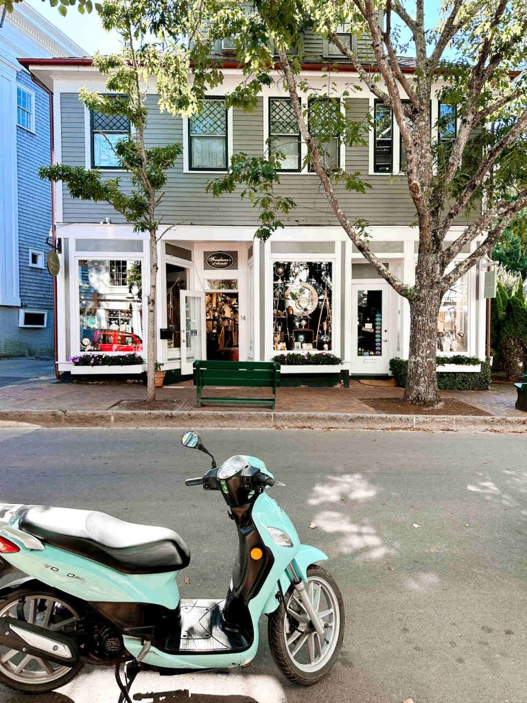 A moped parked outside of shops in downtown Nantucket.