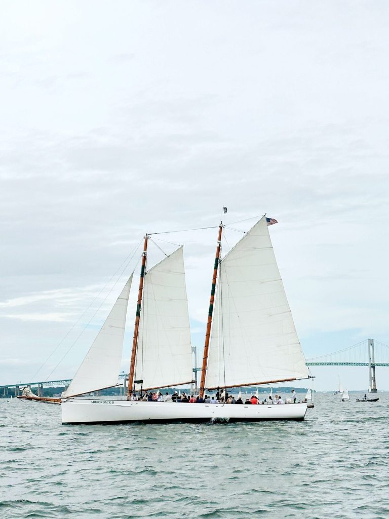 Sailboat sailing in front of a bridge on a cloudy day in Newport, Rhode Island. This sailboat takes hourly tours of the harbor.
