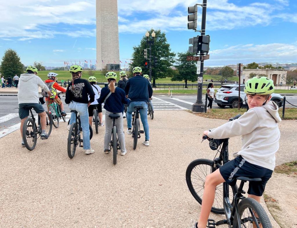 My son and a group of people on a bike tour in front of the Washington Monument.