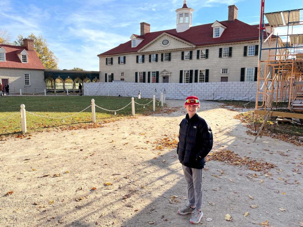 The exterior of George Washington's estate in Mount Vernon with our son standing on front.