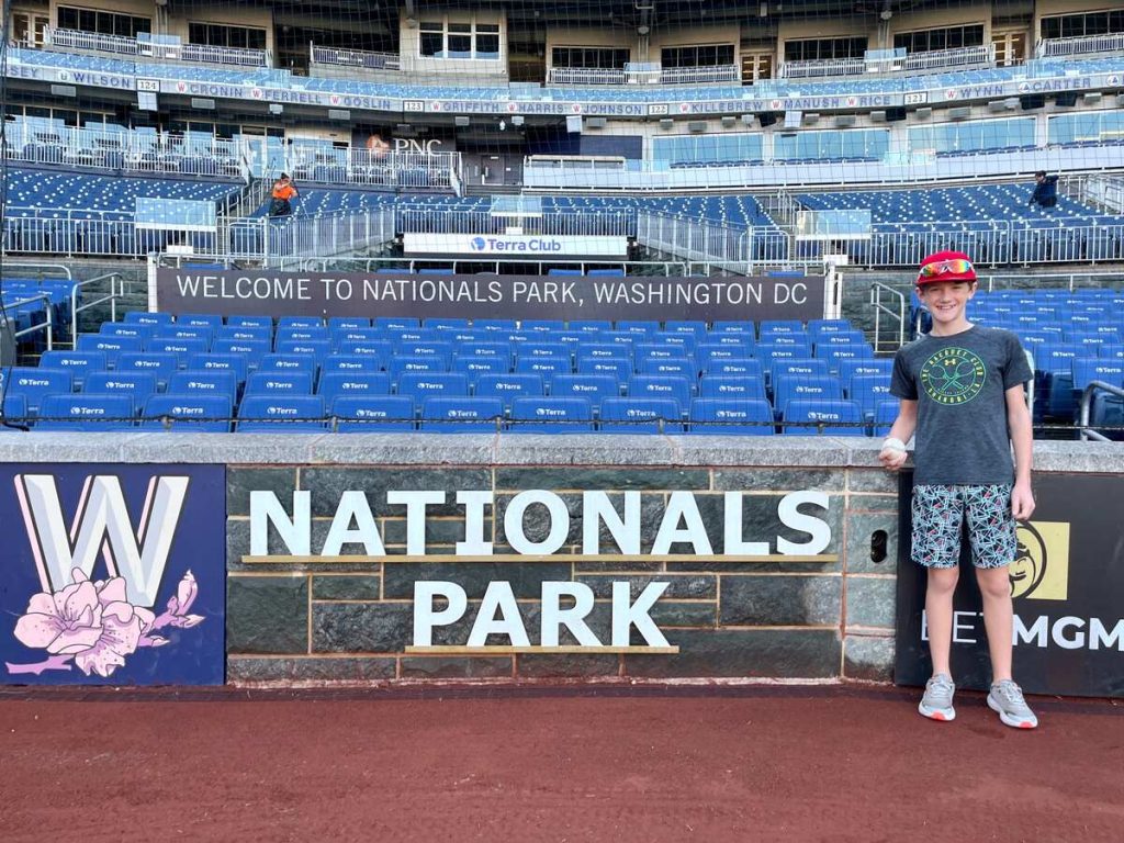 Our son standing inside Nationals Park on the field.