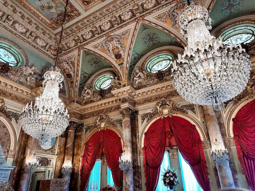 Intricate ceiling detail and extravagant chandeliers at The Breakers Gilded Age mansion in Newport.