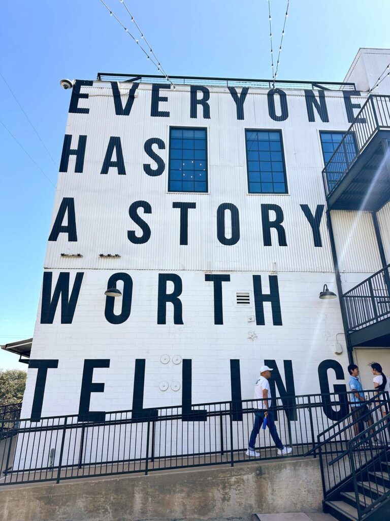 The side of Magnolia Market with a large mural featuring the words "Everyone Has a Story Worth Telling".