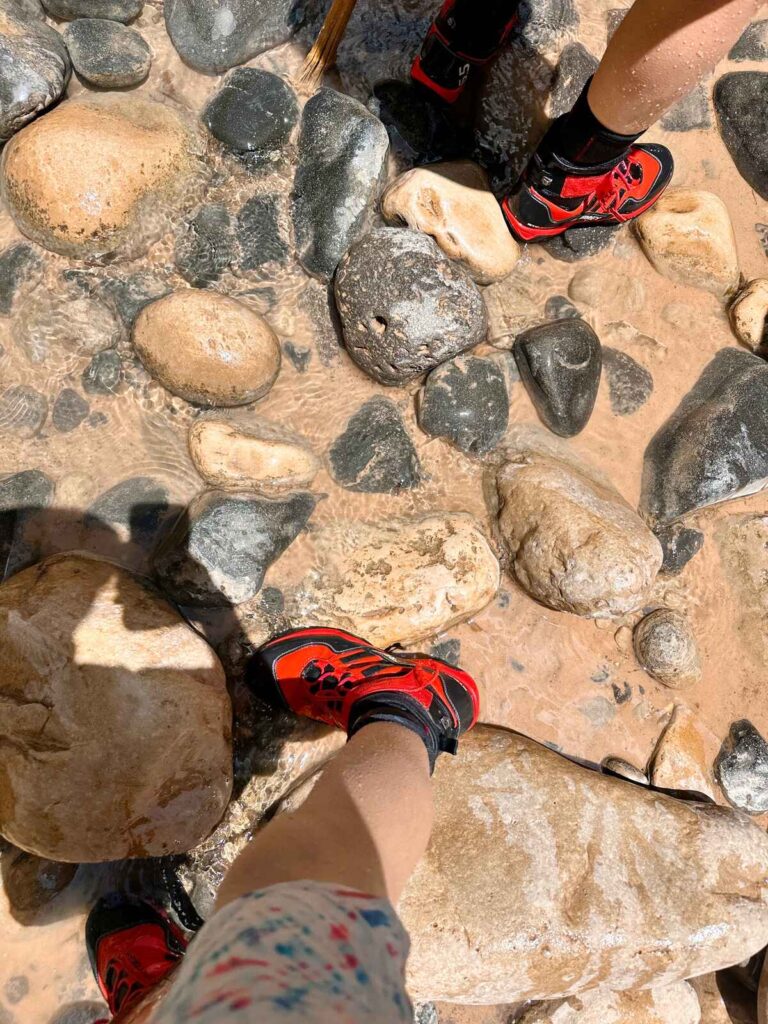 A view of our waterproof hiking book that we rented from Zion Outfitters as we stand in the rocky riverbed.