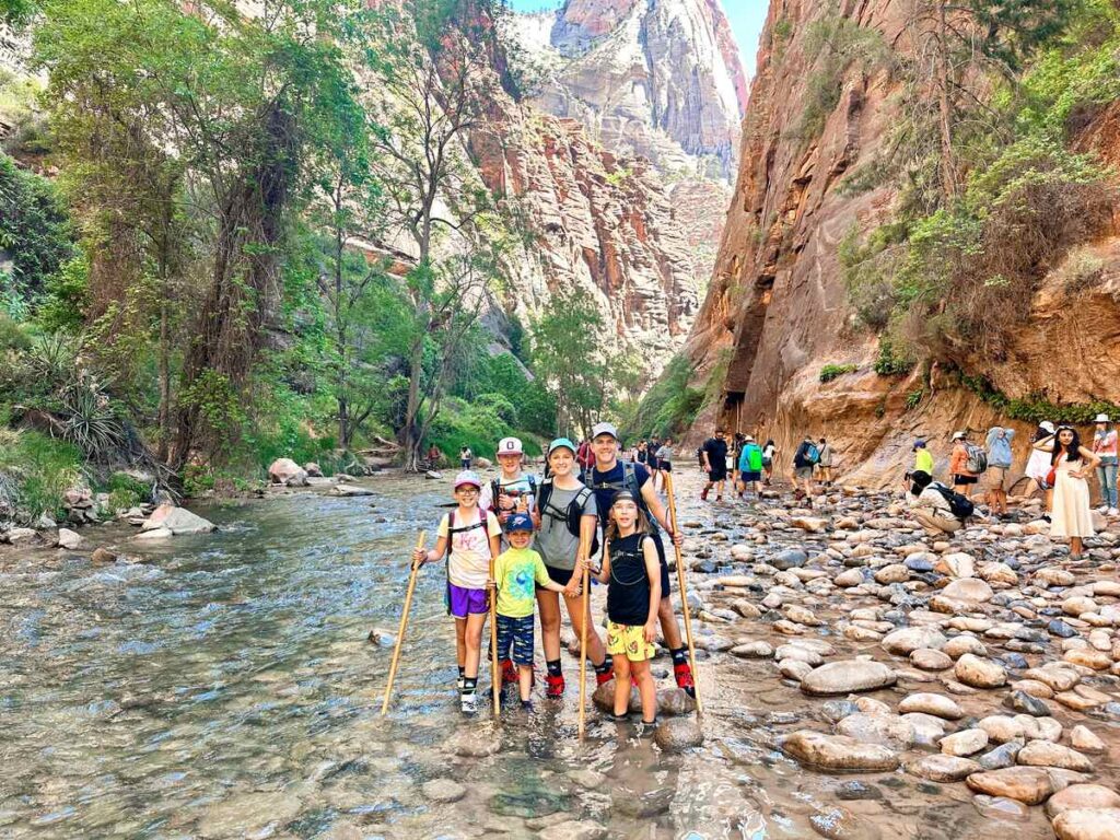 Our family at the Narrows trailhead standing in the river together.