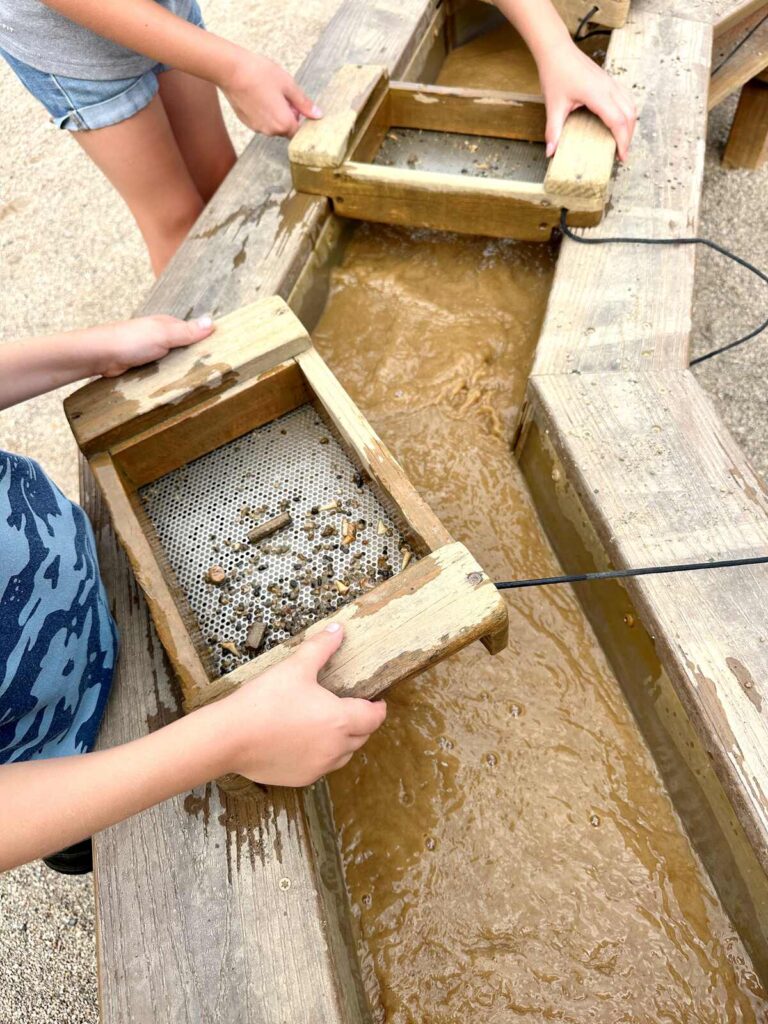 Our kids mining for gemstones and fossils at Beaver's Bend Mining Company. They each have their own sifter to help them find treasures.
