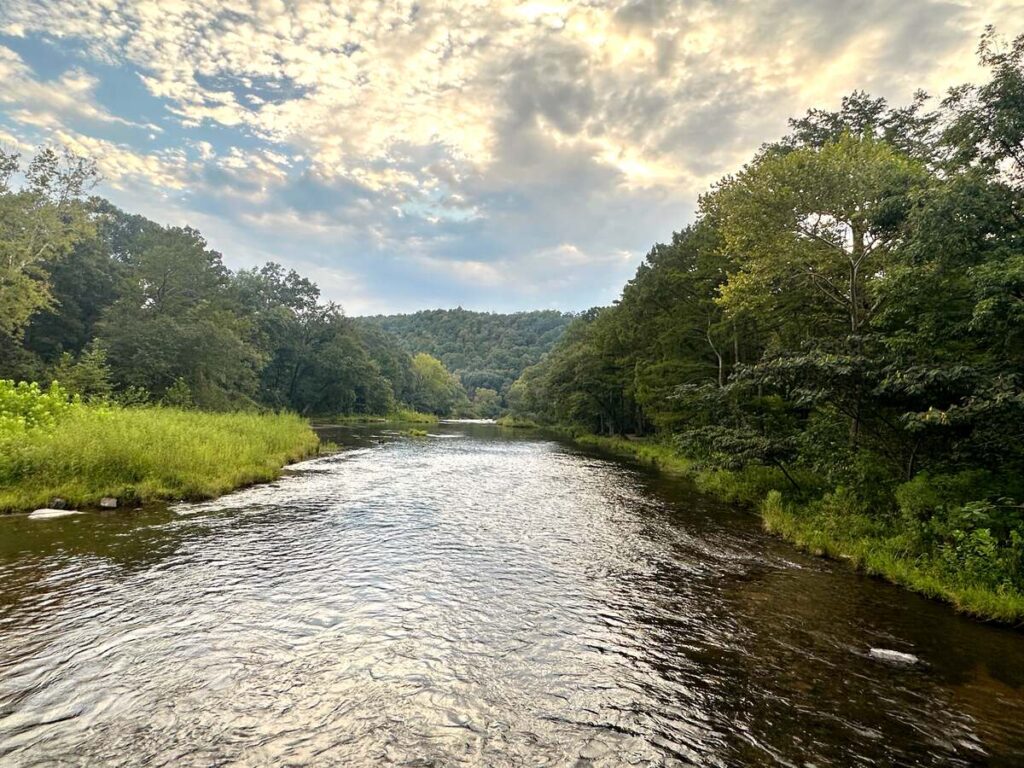 The sun setting over the trees and water in Beaver's Bend State Park.