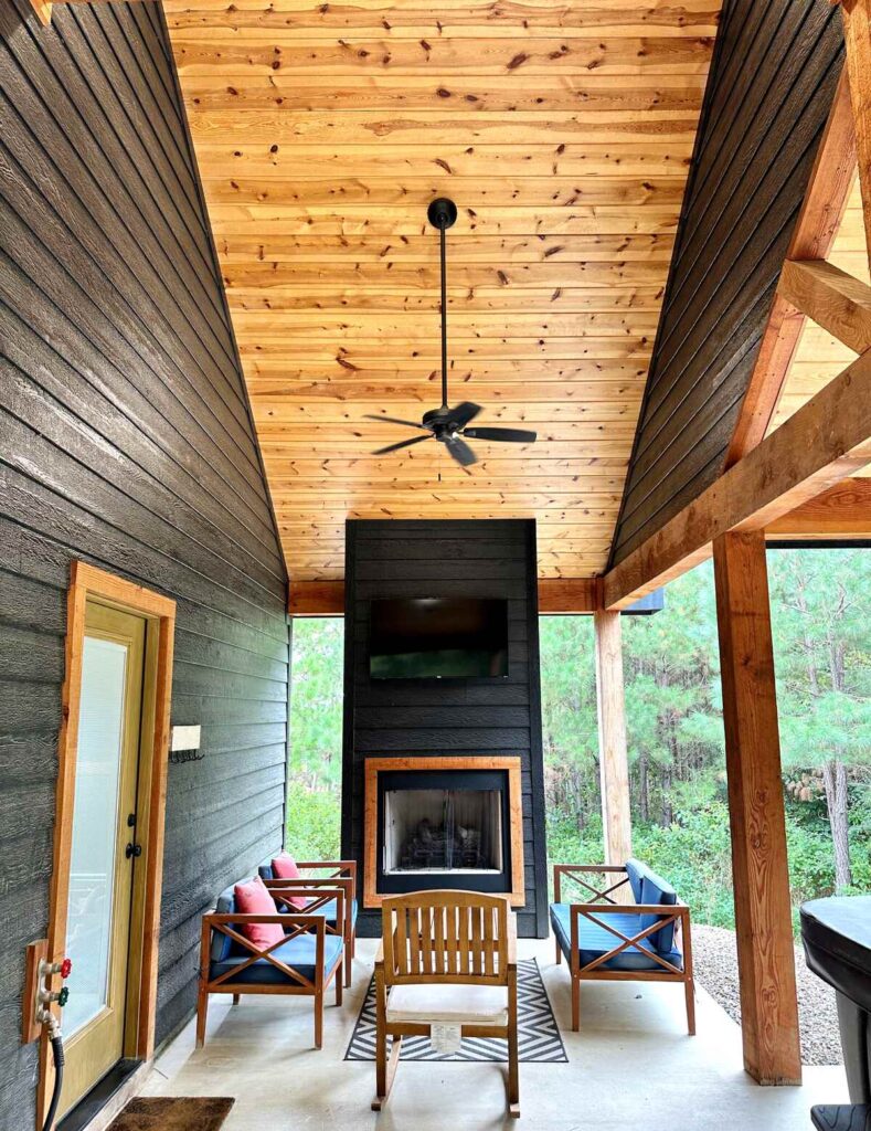 The outdoor space of the vacation rental that we booked in Broken Bow, Oklahoma. The outdoor space has a fire place, seating area, and hot tub.