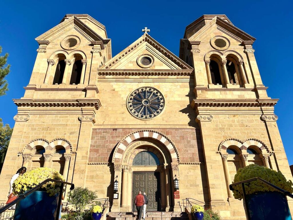 The exterior of The Cathedral Basilica of St. Francis of Assisi against a blue sky.