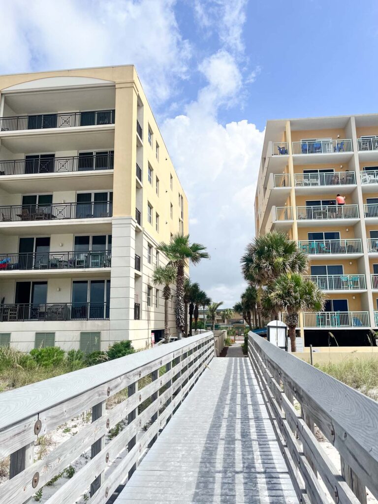 A view of a boardwalk with beautiful condos and vacation rentals in the background.