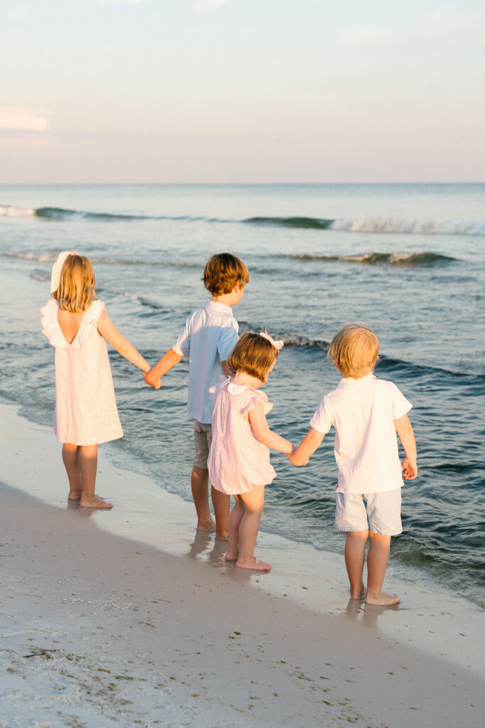My kids holding hands walking along the ocean in Fort Walton Beach, Florida.