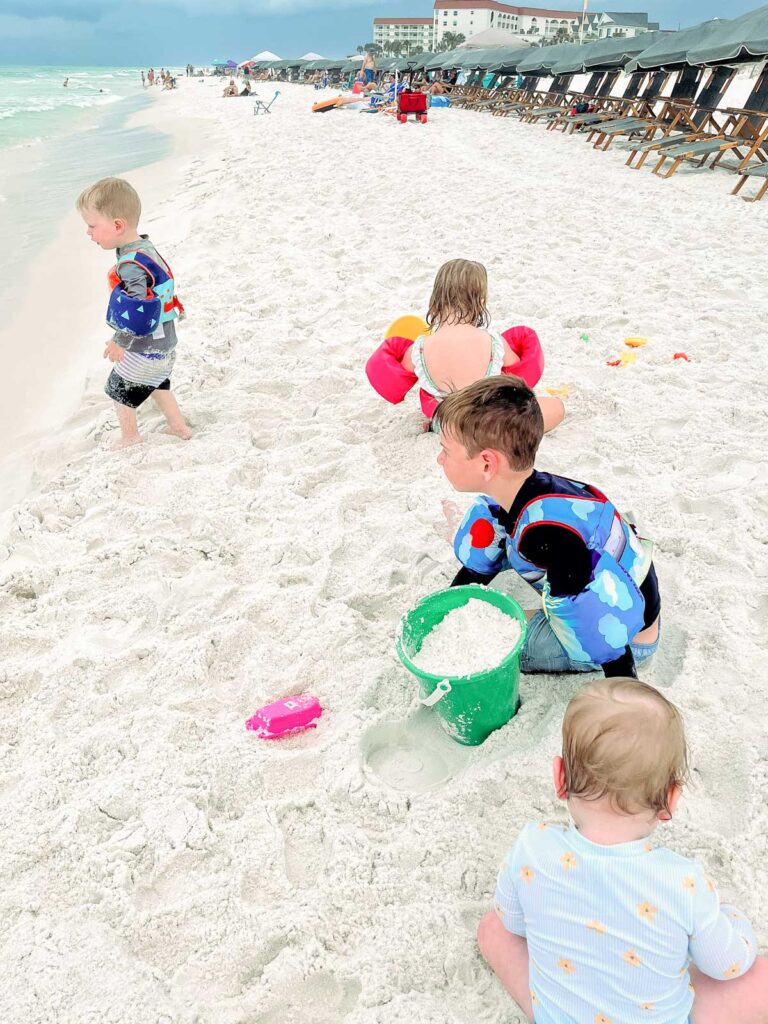 My kids playing in the white sand with shovels and buckets.