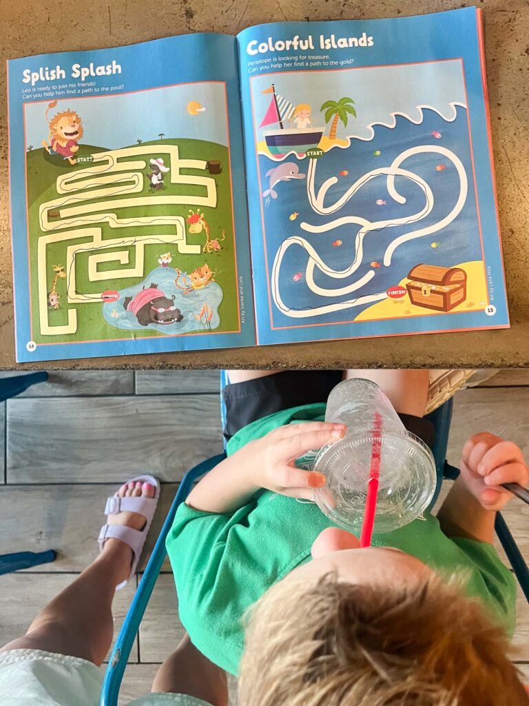 My son coloring in an activity book and drinking water at a restaurant in Fort Walton.