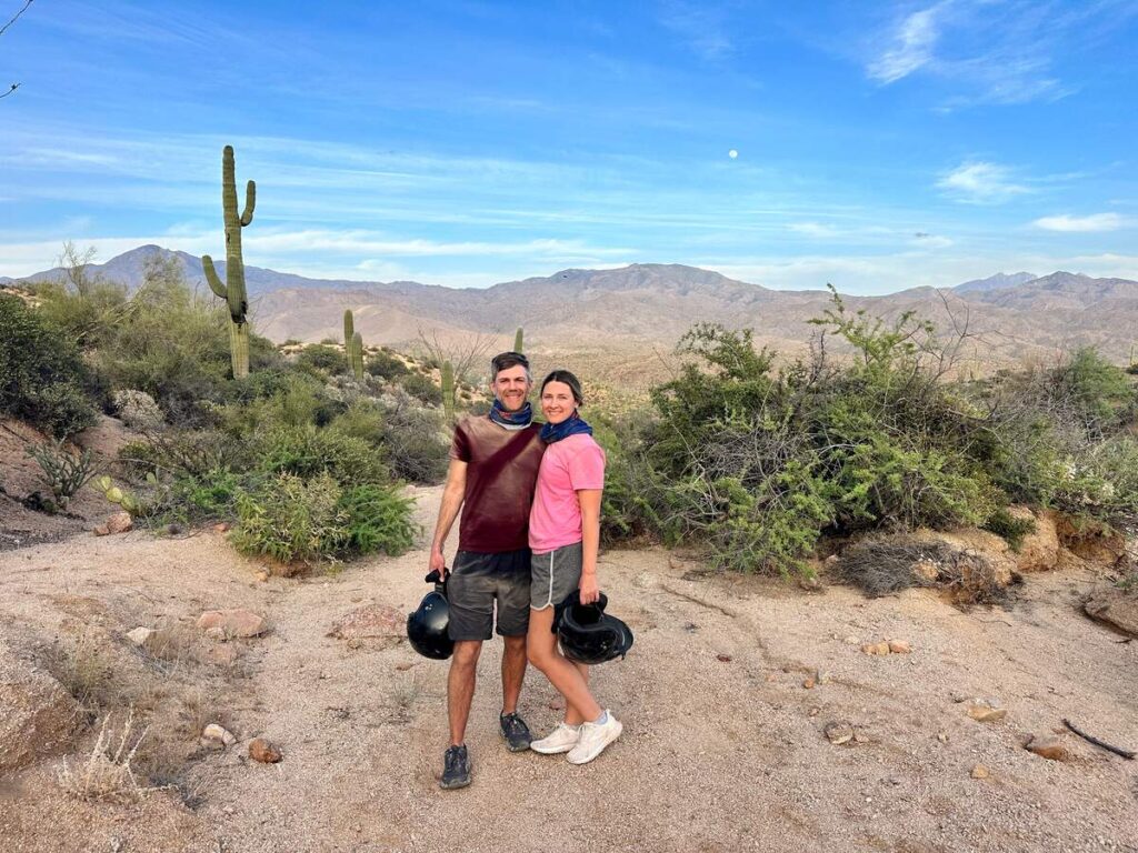 Austin and I standing in front of beautiful desert landscape including cactuses and other desert plants.